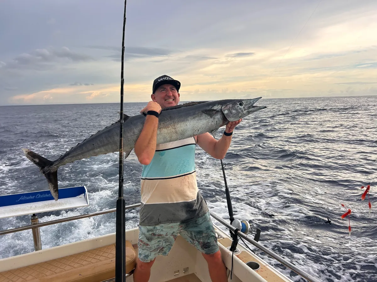 Angler with a wahoo off Los Cabos at sunset