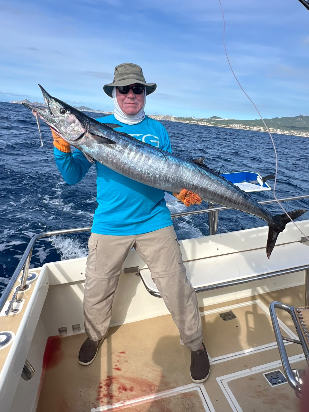 Angler holding a wahoo aboard a sportfishing boat